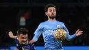 Gelandang Leeds United Jamie Shackleton (kiri) berebut bola dengan gelandang Manchester City Bernardo Silva dalam laga pekan ke-17 Liga Inggris di Etihad Stadium, Rabu (15/12/2021) dini hari WIB. Manchester City mencukur tamunya Leeds United tujuh gol tanpa balas. (Paul ELLIS /AFP)