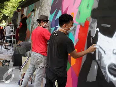 Seniman grafiti menyelesaikan karyanya selama festival Off The Wall di Kawasan Thamrin, Jakarta, Minggu (6/11). Gelaran ini memberikan perspektif baru terhadap seni urban sekaligus memperkenalkan para seniman Grafitti. (Liputan6.com/Gempur M. Surya)