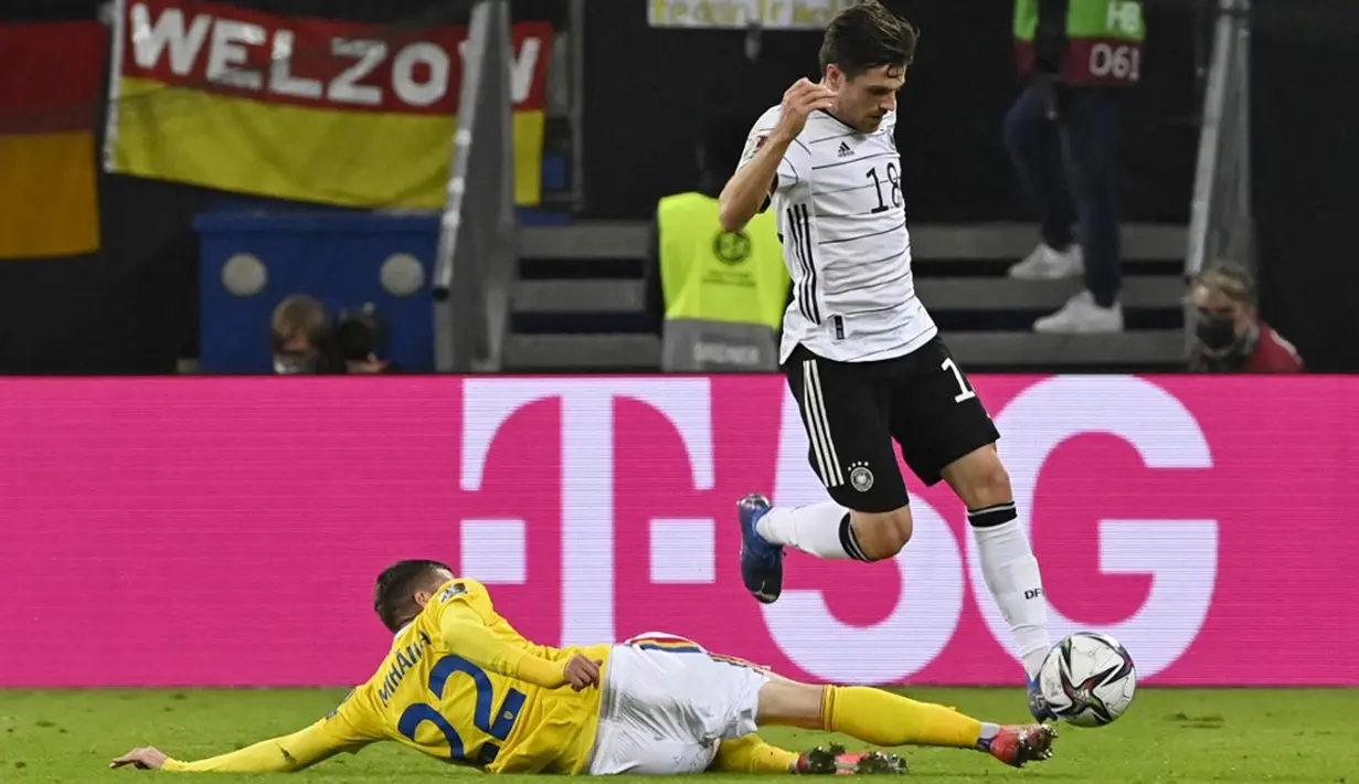 Pemain Rumania Valentin Mihaila (kiri) berebut bola dengan pemain Jerman Jonas Hofmann pada pertandingan Grup J kualifikasi Piala Dunia Qatar 2022 di Hamburg, Jerman, 8 Oktober 2021. Jerman menang 2-1. (John MACDOUGALL/AFP)