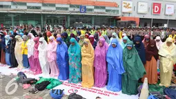 Sejumlah mahasiswa melakukan salat sebelum aksi di JIEXPO, Jakarta (27/4). Mereka menolak pameran mesin rokok international karena dinilai akan berdampak pada jumlah produksi rokok dan konsumsi rokok di Indonesia. (Liputan6.com/Angga Yuniar)