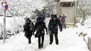 Warga Iran berjalan di tengah salju di Ibu Kota Teheran, Iran, Minggu (28/1). Menurut kantor berita resmi Iran, IRNA, sejumlah daerah pegunungan menerima salju setinggi 1,3 meter (lebih dari empat kaki). (AFP PHOTO/ATTA KENALI)