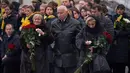 Keluarga korban membawa bunga mawar saat menghadiri upacara penghormatan 11 warga Ukraina yang tewas dalam insiden jatuhnya pesawat Ukraine International Airlines di Iran (8/1) lalu, Bandara Boryspil Kiev, Ukraina, Minggu (19/1/2020). (Ukrainian Presidential Press Service/AFP)
