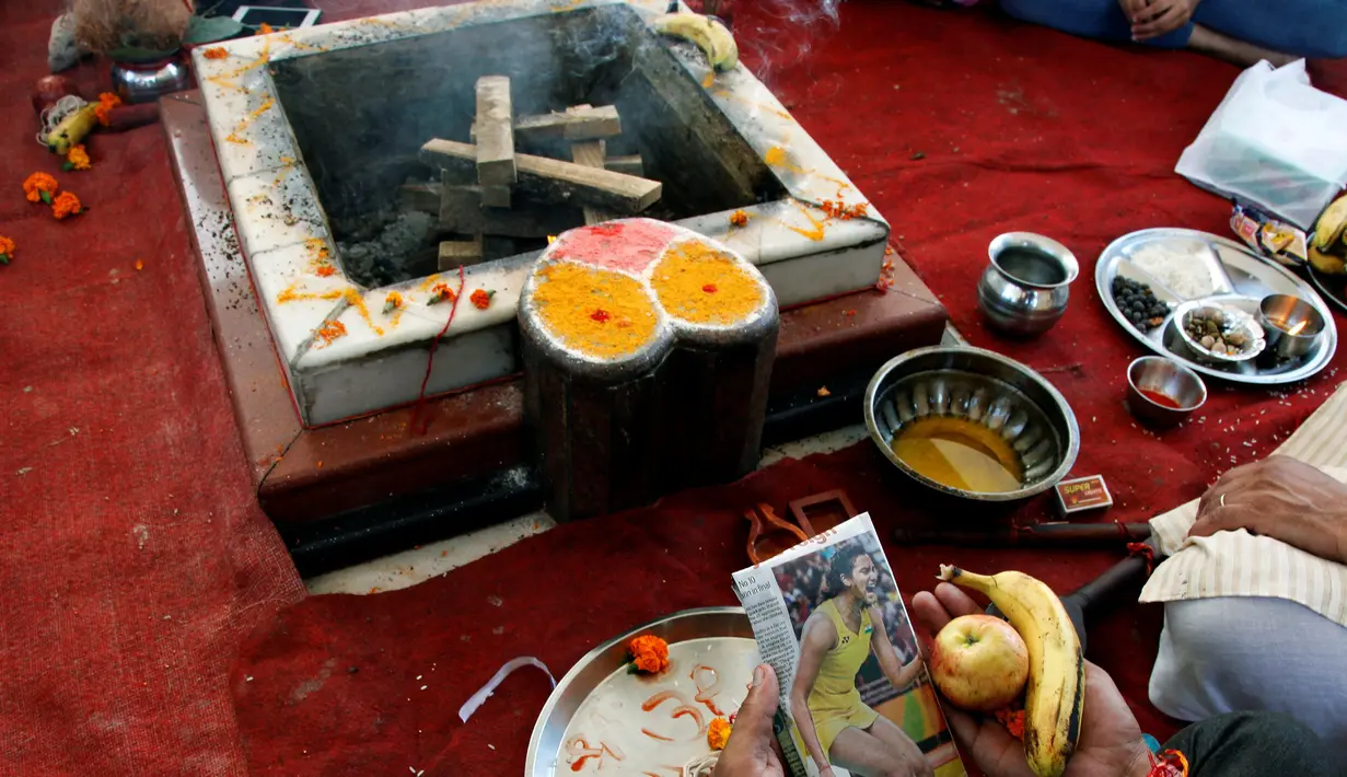 Warga melakukan ritual doa untuk atlet bulu tangkis mereka, P.V. Sindhu yang mengikuti Olimpiade 2016 untuk mendapatkan medali emas di Chandigarh , India , 19 Agustus 2016. Sambil memegang foto P.V. Sindhu mereka berdoa bersama. (REUTERS / Ajay Verma)