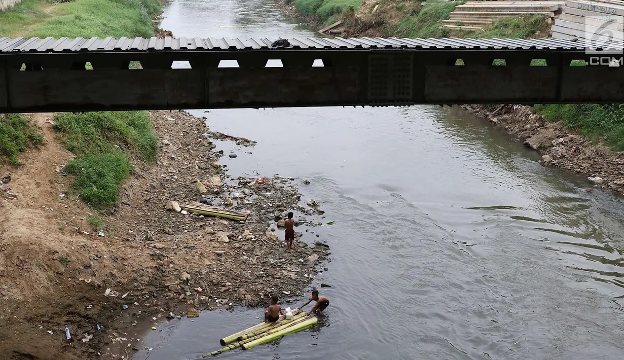 Anak-anak berenang menggunakan batang pohon pisang di bantaran Sungai Ciliwung, Jakarta, Selasa (15/5). Kurangnya pengawasan menyebabkan anak-anak tersebut bermain tidak pada tempatnya. (Liputan6.com/Immanuel Antonius)