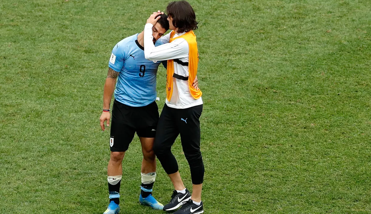 Striker Uruguay, Edinson Cavani menghibur rekan setimnya, setelah kalah atas Prancis pada akhir laga perempat final Piala Dunia 2018 di Nizhny Novgorod Stadium, Jumat (6/7). Timnas Uruguay tersingkir usai ditumbangkan Prancis 0-2 . (AP/Hassan Ammar)