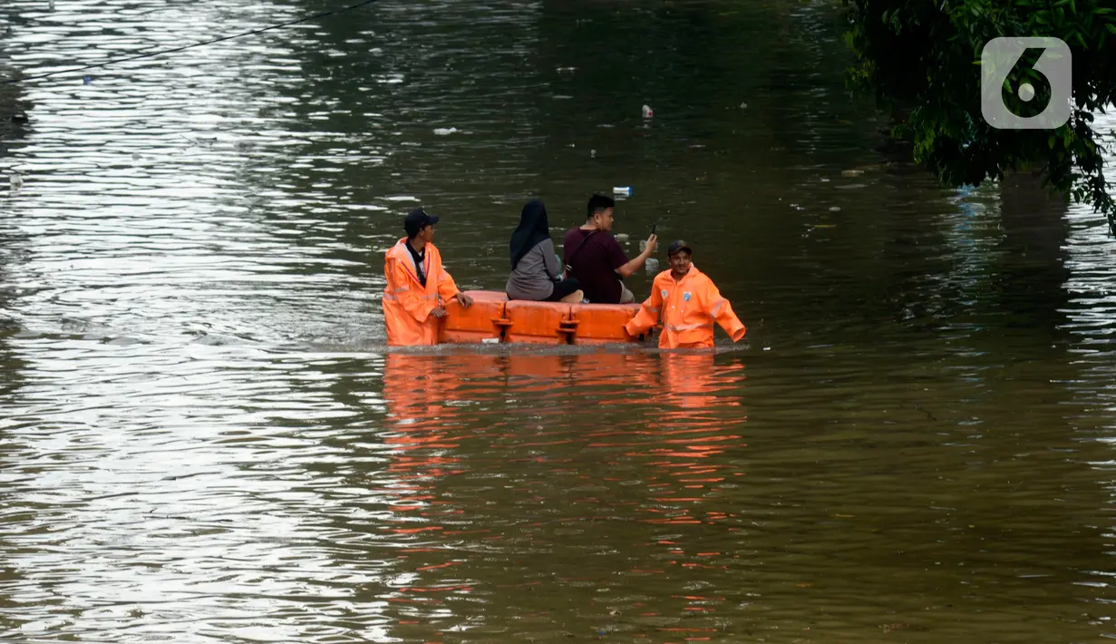 Petugas mengevakuasi warga melewati Jalan Letjen Suprapto yang terendam banjir, Jakarta Pusat, Sabtu (8/2/2020). Hujan yang mengguyur Jakarta sejak semalam mengakibatkan Jalan Letjen Suprapto terendam banjir. (merdeka.com/Imam Buhori)