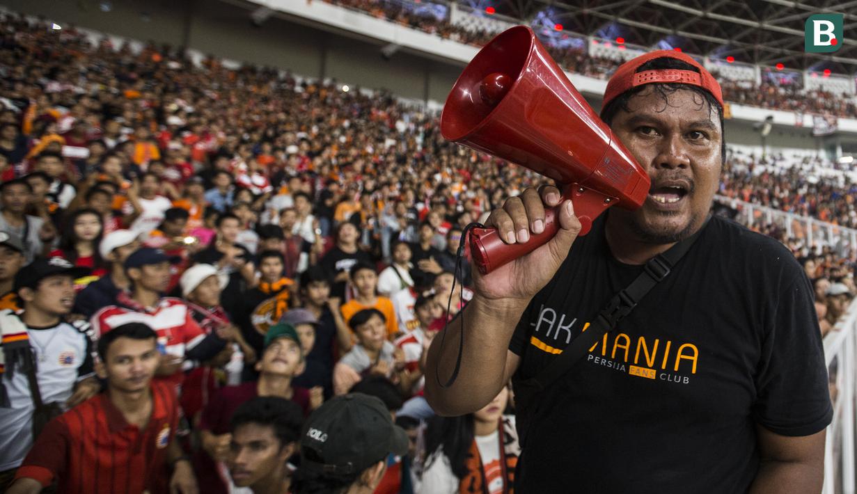 Seorang suporter Persija Jakarta, The Jakmania, memberikan aba-aba saat melawan Johor Darul Ta'zim pada laga Piala AFC di SUGBK, Jakarta, Selasa (10/4/2018). Persija menang 4-0 atas JDT. (Bola.com/Vitalis Yogi Trisna)