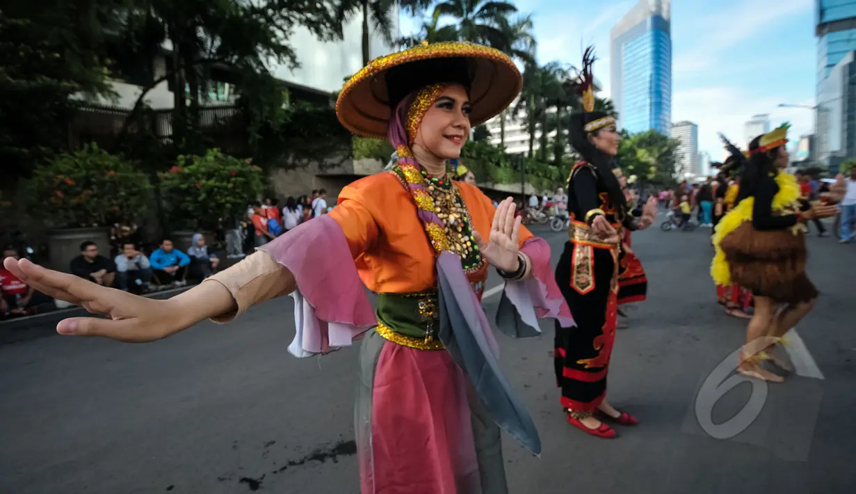 Seorang penari T-Ta menari saat car free day di Bundara HI, Jakarta, Minggu (26/4/2015). Mereka meminta sumbangan kepada warga untuk mengikuti Interntional Folklore Festival di Spanyol. (Liputan6.com/Faizal Fanani)