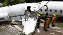 Petugas layanan darurat berada di lokasi pesawat jet pribadi Gulfstream G200 yang tergelincir di Bandara Tegucigalpa, Honduras, Selasa (22/5). Bandara Tegucigalpa telah lama dikenal sebagai salah satu bandara berbahaya. (AP/Fernando Antonio)