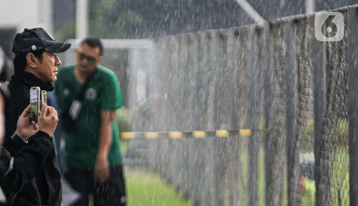 Pelatih Shin Tae-yong memantau kondisi lapangan saat sesi latihan Timnas Indonesia menjelang laga leg pertama kontra Vietnam pada semifinal Piala AFF 2022, di Lapangan A Kompleks Gelora Bung Karno, Jakarta, Rabu (4/1/2023). Timnas Indonesia sulit berlatih karena hujan deras yang menyebabkan Lapangan A SUGBK banjir dan banyak genangan. (Liputan6.com/Faizal Fanani)