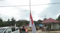 Bendera Merah Putih setengah tiang berkibar di rumah-rumah warga, menyambut kedatangan jenazah almarhum Letnan Satu Anumerta Marinir Muhammad Iqbal, di Desa Anggotoa, Kecamatan Wawotobi, Kabupaten Konawe, Provinsi Sulawesi Tenggara. (Liputan6.com/ Ist