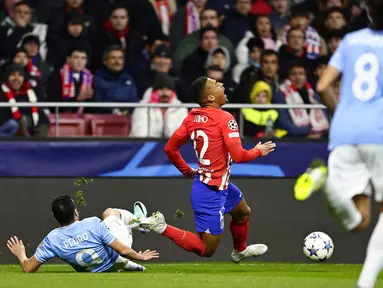 Pemain Atletico Madrid, Samuel Lino, terjatuh saat berebut bola dengan pemain Lazio, Pedro, pada laga grup E Liga Champions di Stadion Metropolitano, Madrid, Kamis (14/12/2023). Atletico menang dua gol tanpa balas. (AP Photo/Pablo Garcia)