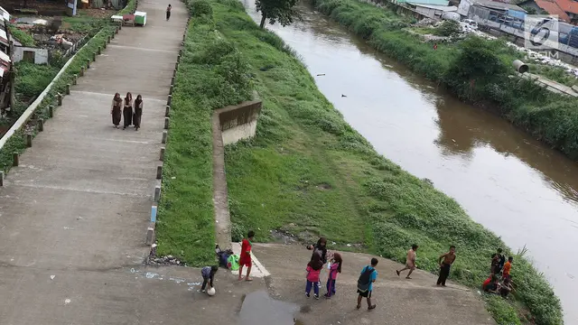 Keseruan Anak-Anak Bermain Sepak Bola di Jalur Inspeksi Ciliwung