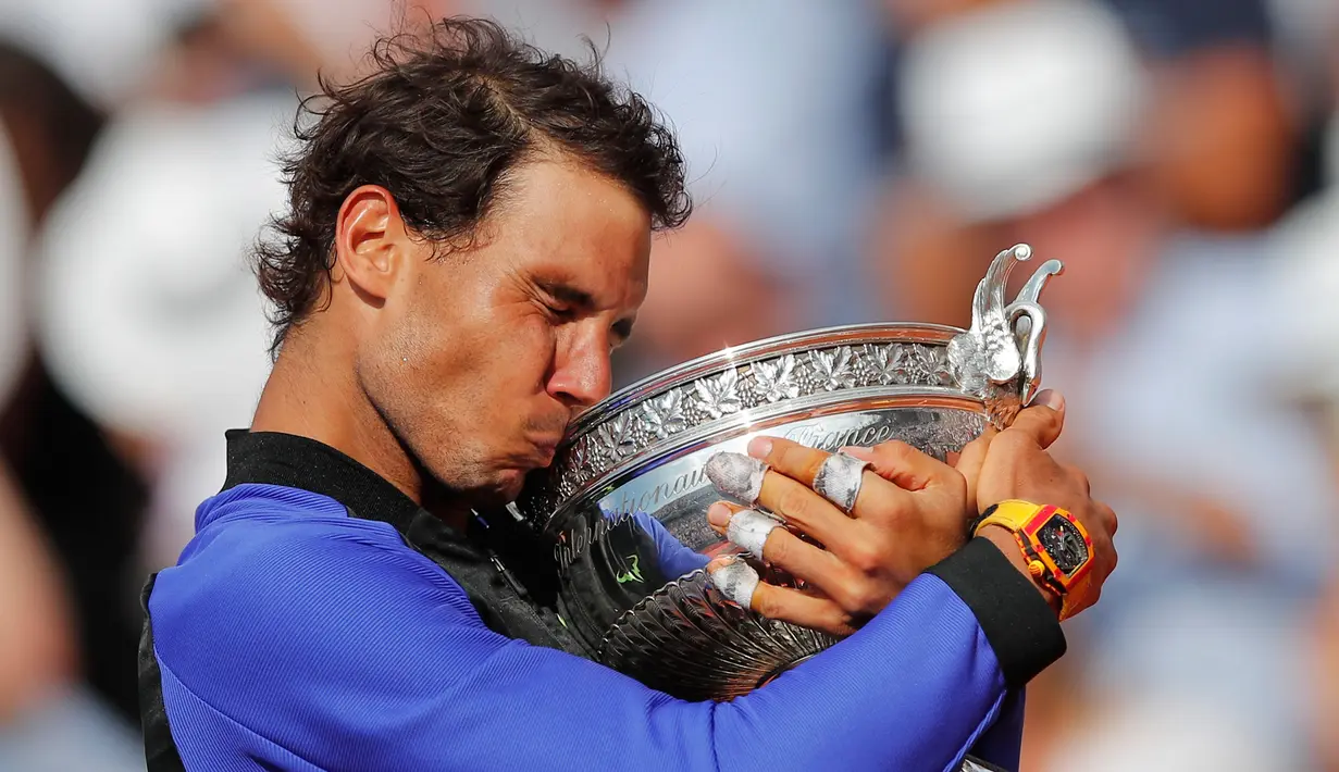 Petenis Spanyol, Rafael Nadal mencium trofinya setelah mengalahkan Stan Wawrinka pada final Prancis Terbuka di Roland Garros, Minggu (11/6). Nadal unggul dengan skor 6-2, 6-3, 6-1 untuk meraih gelar kesepuluh atau La Decima. (AP Photo/Christophe Ena)