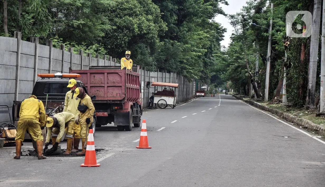 Pekerja Suku Dinas Bina Marga Jakarta Utara menyelesaikan perbaikan jalan jelang gelaran balap liar legal di Jalan Inspeksi Kali Ancol, Pademangan, Rabu (12/1/2022). Balap liar legal yang dinamai Street Race rencananya akan digelar perdana pada akhir pekan mendatang. (merdeka.com/Iqbal S. Nugroho)