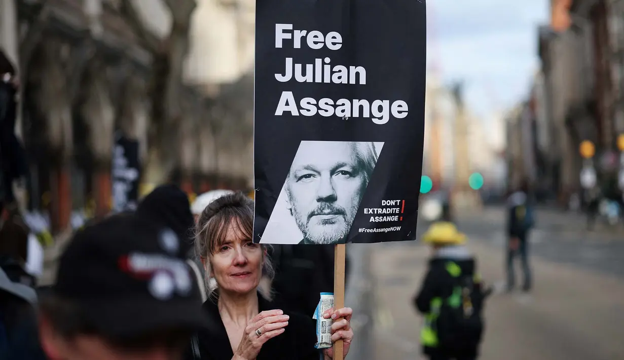 Seorang demonstran memegang plakat bergambar pendiri WikiLeaks, Julian Assange dalam sebuah protes di luar Royal Courts of Justice, Pengadilan Tinggi Inggris, di pusat kota London, pada tanggal 20 Februari 2024. (Daniel LEAL/AFP)