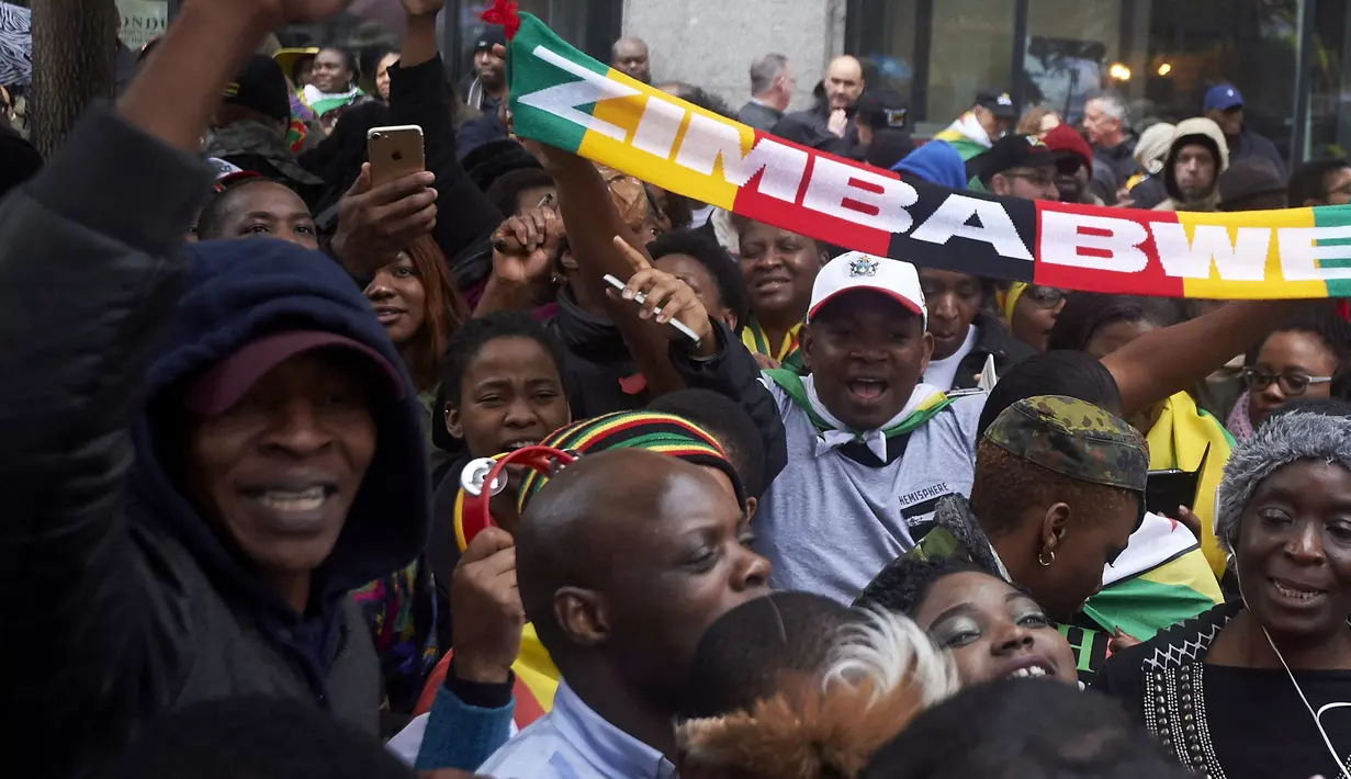 Warga Zimbabwe yang menetap di Inggris menggelar aksi protes di luar Kedutaan Besar Zimbabwe di London, Sabtu (18/11). Mereka berkumpul mendukung runtuhnya rezim Presiden Robert Mugabe. (NIKLAS HALLE'N/AFP)