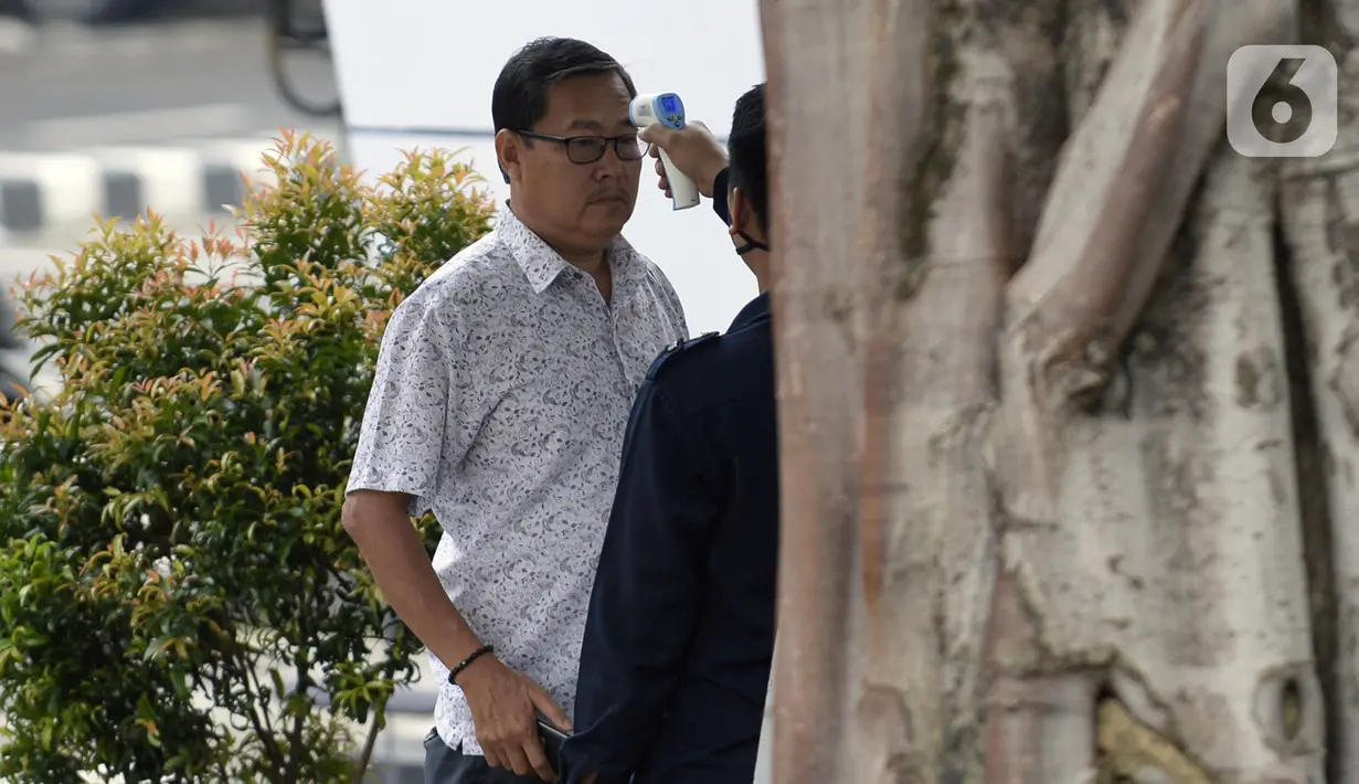 Mantan Ketua DPRD Kabupaten Bengkalis Abdul Kadir diperiksa suhu tubuh oleh petugas saat tiba di Gedung KPK, Jakarta, Rabu (18/3/2020). Abdul Kadir diperiksa sebagai saksi untuk tersangka Bupati nonaktif Bengkalis Amril Mukminin terkait dugaan suap. (merdeka.com/Dwi Narwoko)