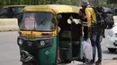 Penumpang bernegosiasi dengan pengemudi becak di luar stasiun kereta api selama pemogokan oleh operator transportasi swasta di New Delhi, India, 18 April 2022. Berbagai serikat pekerja bajaj dan taksi di ibu kota mogok menuntut subsidi untuk gas alam terkompresi. (AP Photo/Manish Swarup)