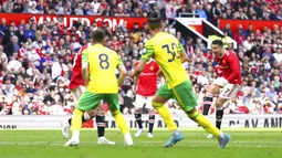 Pemain Manchester United Cristiano Ronaldo (kanan) mencetak gol ke gawang Norwich City pada pertandingan sepak bola Liga Inggris di Stadion Old Trafford, Manchester, Inggris 16 April 2022. Manchester United menang 3-2. (AP Photo/Jon Super)