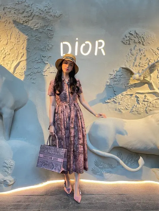 Ia kenakan dress lengan pendek yang dipadukan dengan topi pantai dan tote bag Dior [@vaelovevexia]