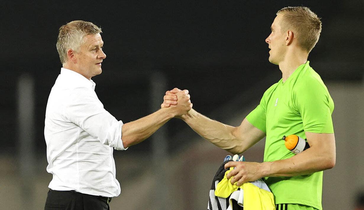 Kiper Copenhagen, Karl-Johan Johnsson, berjabat tangan dengan pelatih Manchester United, Ole Gunnar Solskjaer, pada laga Liga Europa di Stadion Rhein Energie, Senin (10/8/2020). MU menang tipis 1-0 atas Copenhagen.  (Wolfgang Rattay/Pool via AP)