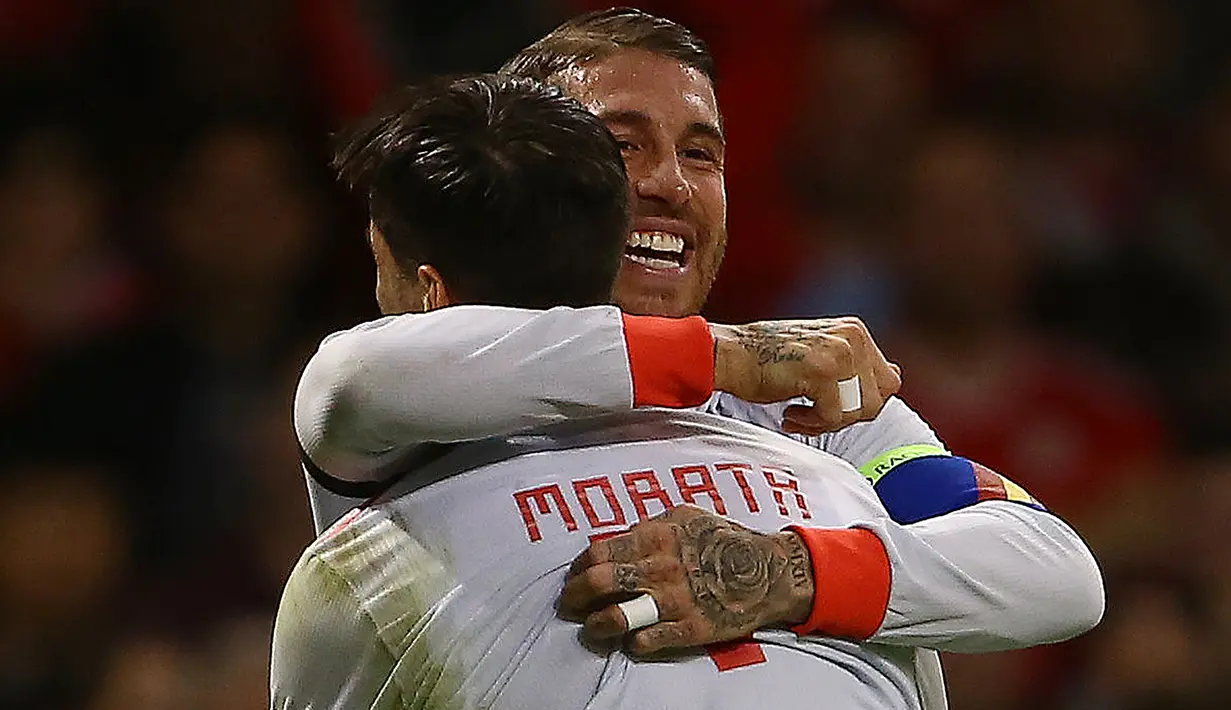 Bek Spanyol, Sergio Ramos berselebrasi dengan Alvaro Morata usai mencetak gol ke gawang Wales pada uji coba internasional di Stadion Principality, Cardiff, Inggris (11/10). Spanyol menang telak 4-1 atas Wales. (AFP Photo/Geoff Caddick)