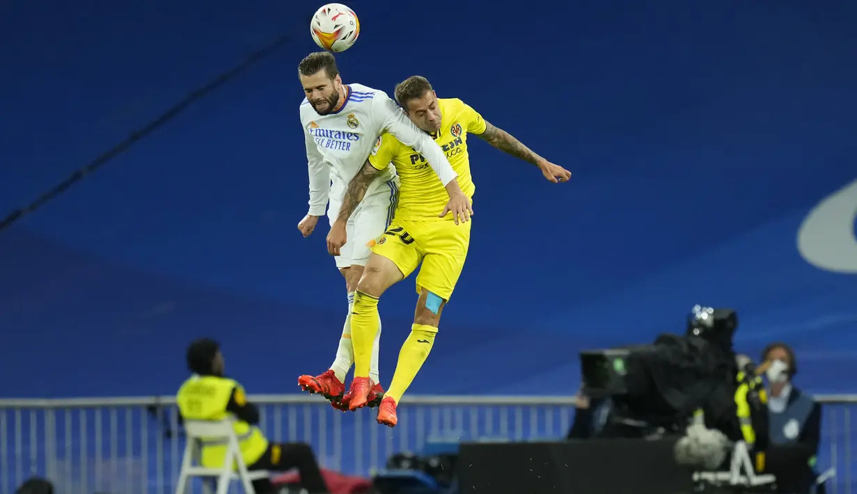 Bek Real Madrid Nacho dan gelandang Villarreal Ruben Pena melompat saat berebut bola pada jornada ketujuh La Liga Spanyol di Santiago Bernabeu, Minggu (26/9/2021) dini hari WIB. Real Madrid hanya mampu bermain imbang tanpa gol kala menjamu Villarreal. (AP Photo/Manu Fernandez)