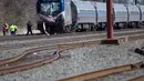 Kereta penumpang Amtrak tergelincir setelah terlibat kecelakaan dengan menabrak backhoe di dekat Philadelphia, Amerika Serikat, Minggu (3/4). Sedikitnya 2 orang tewas dan 30 lainnya mengalami luka-luka akibat kejadian ini. (Mark Makela/Getty Images/AFP)