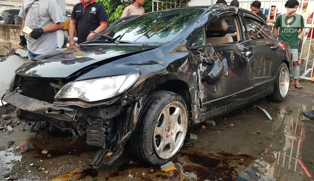 Warga melihat kondisi mobil yang mengalami kecelakaan tunggal di kawasan Pasar Minggu, Jakarta Selatan, Sabtu (8/6/2019). Mobil yang nyaris tercebur sungai itu dikendarai seorang pemuda yang nekat melakukan aksi kebut-kebutan saat jalanan ibu kota lengang. (Liputan6.com/Herman Zakharia)