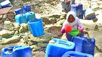 Warga menuangkan air yang diambil dari cekungan batu ke jeriken di Desa Banyoneng Laok, Kecamatan Geger, Bangkalan. (BADRI STIAWAN/radarmadura.id)