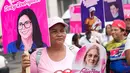 Seorang perempuan memegang poster bergambar mantan Ibu Negara Venezuela, Cilia Flores, saat mengikuti pawai yang diselenggarakan pemerintah untuk meningkatkan kesadaran tentang kanker payudara dalam rangka Bulan Peduli Kanker Payudara di Caracas, Venezuela, Kamis (22/10/2026). (AP Photo/Pedro Mattey)