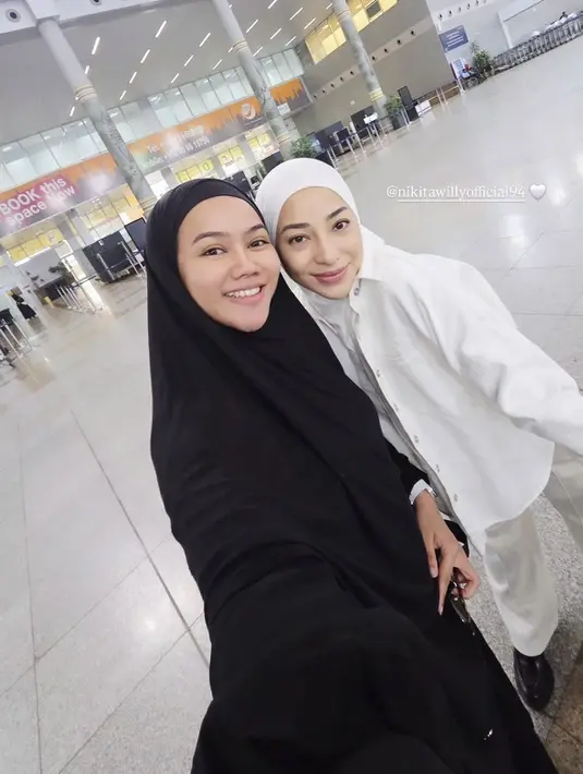 Nikita Willy terlihat berangkat umrah bersama suami dan adiknya, Winona. Berfoto bersama Yura Yunita, Nikita Willy mengenakan kerudung putih senada dengan atasan kemeja dan celana putih panjang. [@yurayunita]