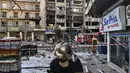 Seorang petugas pemadam kebakaran memeriksa kerusakan setelah ledakan menghancurkan bangunan di pusat daerah Athena (26/1/2022). Penyebab ledakan belum diketahui, meskipun gambar dari tempat kejadian menunjukkan kerusakan signifikan pada beberapa bangunan. (AFP/Louisa Gouliamaki)