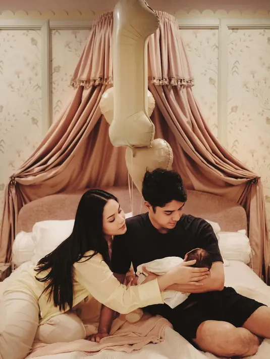 Alih-alih menggelar pesta besar, pasangan ini memilih perayaan yang terasa personal. Dekorasi kamar dipenuhi sentuhan warna blush pink dan krem yang lembut.  [@alyssadaguise].
