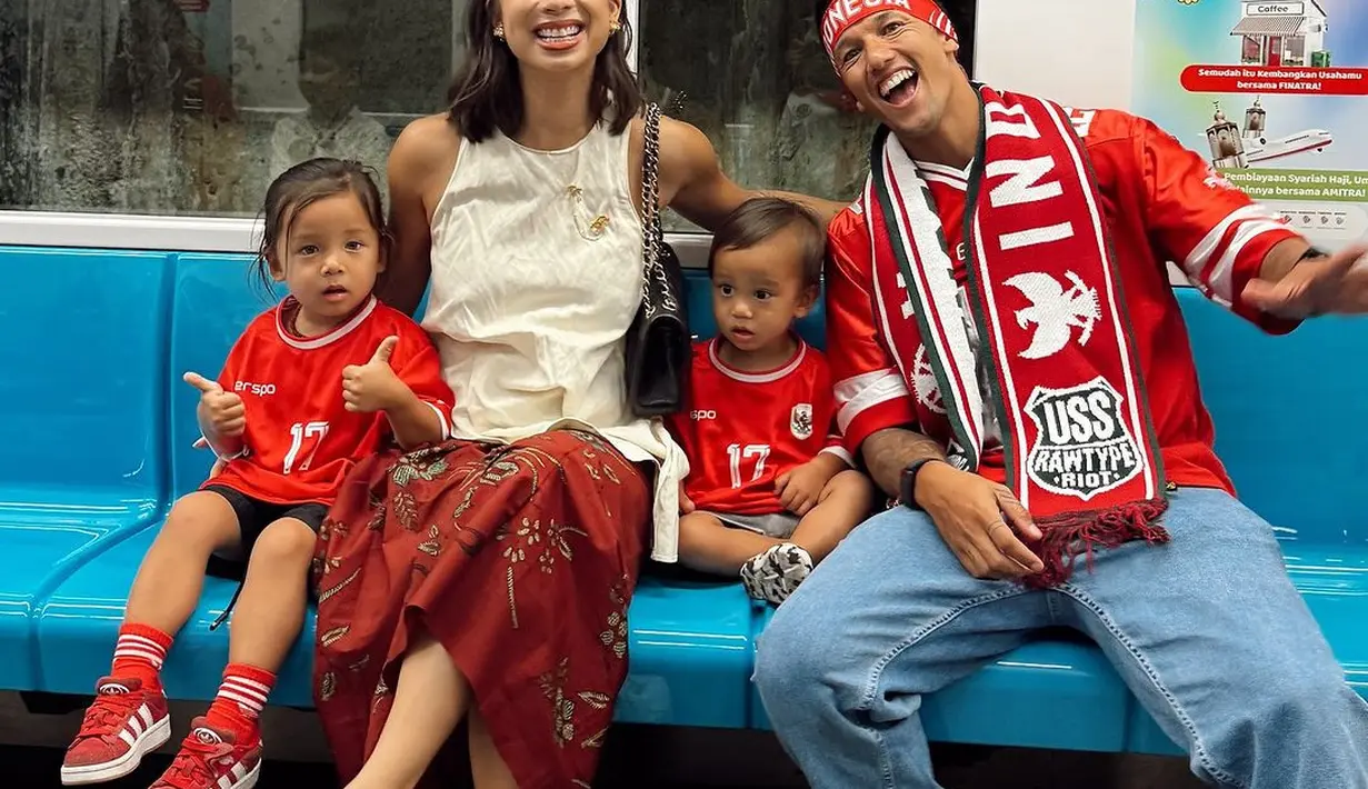 Nonton bareng keluarga kecilnya, Jennifer Bachdim memilih mengenakan busana etnik namun tetap dengan nuansa merah putih. Sementara Irfan dan buah hati mereka kompak kenakan jersey timnas merah. [@jennifer bachdim].