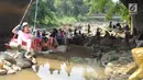 Seorang anak bermain ayunan di kolong jembatan Sempur, Bogor (16/9). Musim kemarau yang menyebabkan debit Sungai Ciliwung menyusut drastis dimanfaatkan warga Bogor dan sekitarnya untuk berwisata murah dan gratis di aliran sungai. (Merdeka.com/Arie Basuki)