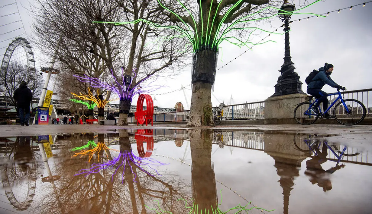 Seorang pria bersepeda di sepanjang Southbank yang sepi di pusat Kota London, Inggris, 12 Januari 2021. Inggris sedang menerapkan lockdown nasional ketiga untuk mengekang penyebaran virus corona COVID-19. (Victoria Jones/PA via AP)