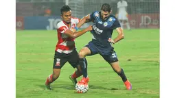 Pemain Arema Cronus, Srdan Lopicic (kanan) berusha keluar dari tekanan pemain Madura United, Asep Berlian pada laga Torabika Soccer Champions 2016 di Stadion Gelora Bangkalan, Jumat (6/5/2016) WIB. (Bola.com/Iwan Setiawan)