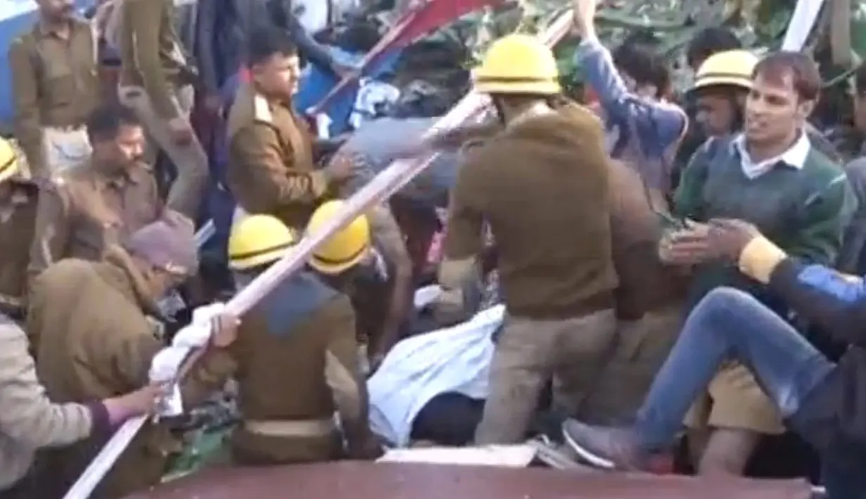 Petugas penyelamat berusaha mengevakusi korban tergelincirnya kereta Indian Express di Negara Bagian Uttar Pradesh, India, Minggu (20/11). Sedikitnya 60 orang tewas dan lebih dari 150 lainnya terluka. (ANI/via REUTERS)