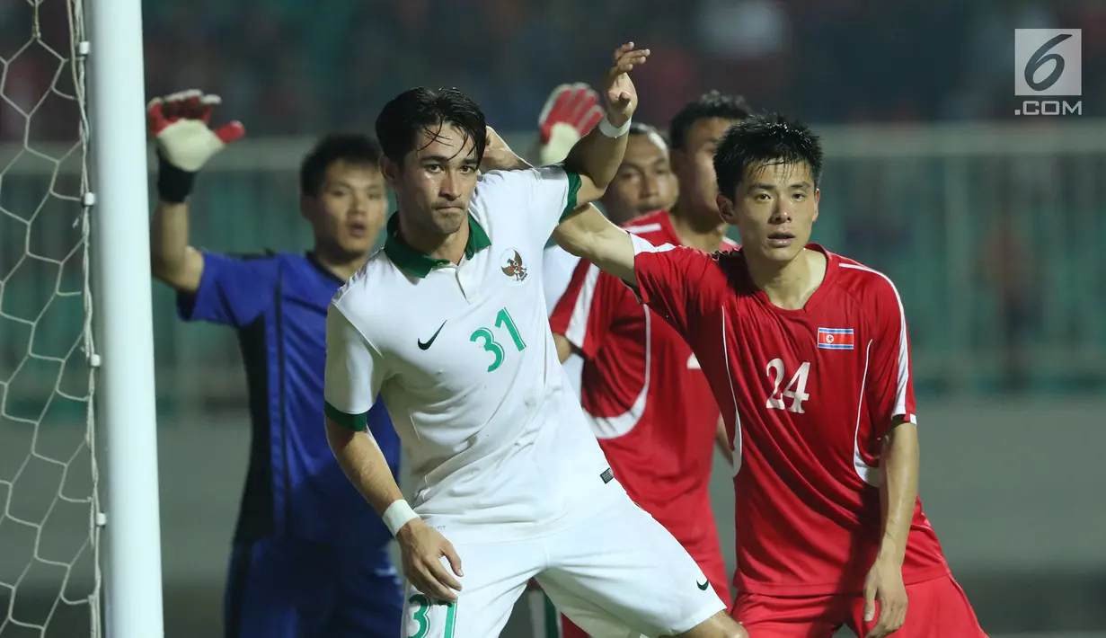 Pemain belakang Indonesia U-23, Gavin Kwan Adsit (kedua kiri) berebut posisi dengan pemain Korea Utara, Kim Kum Chol pada laga PSSI Anniversary Cup 2018 di Stadion Pakansari, Kab Bogor, Senin (30/4). (Liputan6.com/Helmi Fithriansyah)