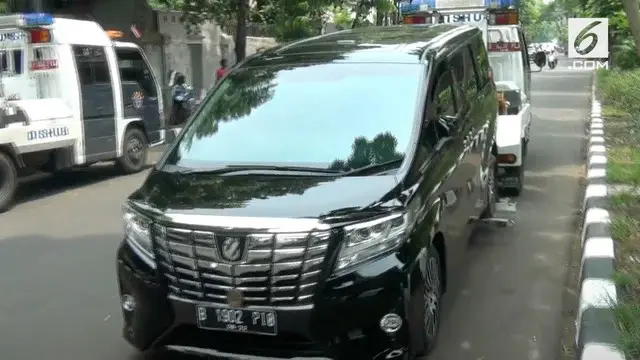 Sebuah mobil milik anggota DPR RI diderek petugas karena parkir sembarangan.