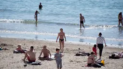 Orang-orang berjemur dan berenang di pantai Catalans (Plage des Catalans) di Marseille, Prancis Selatan, (17/4). Pantai ini memiliki dua lapangan voli pantai di mana beberapa kompetisi internasional diselenggarakan. (AFP Photo/Bertrand Langlois)