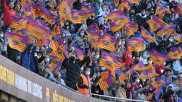 Camp Nou yang dipadati sekitar seribuan penonton menyambut kedatangan Xavi dengan kibaran bendera klub sambil mengelukan nama mantan kapten Barcelona tersebut penuh sukacita. (AFP/Lluis Gene)