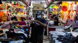 Pedagang pakaian menata dagangannya di Pasar Tanah Abang, Jakarta, Selasa (27/7/2021). Pasar Tanah Abang yang kembali dibuka mulai Senin (26/7) mewajibkan pengunjung serta pedagang menunjukkan sertifikat vaksinasi COVID-19 untuk masuk ke pasar. (Liputan6.com/Johan Tallo)