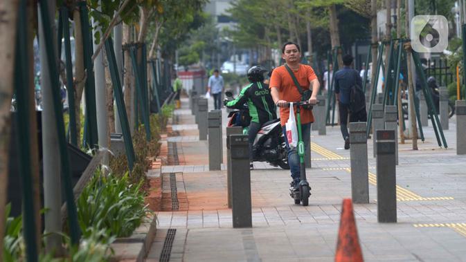 Seorang pria mengendarai skuter listrik di trotoar Jakarta, Jumat (22/11/2019). Tidak ada sanksi dari Pemprov DKI Jakarta terhadap pengguna skuter listrik selama regulasi yang mengatur masih dalam pembahasan. (merdeka.com/Imam Buhori)