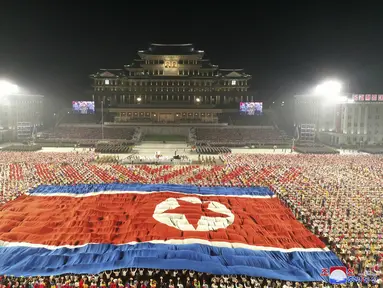 Bendera besar Korea Utara ditampilkan selama perayaan ulang tahun ke-73 negara itu di Lapangan Kim Il Sung di Pyongyang, Kamis (9/9/2021). Korea Utara dilaporkan menggelar parade militer pada Kamis dini hari dalam rangka merayakan HUT ke-73. (Korean Central News Agency/Korea News Service via AP)