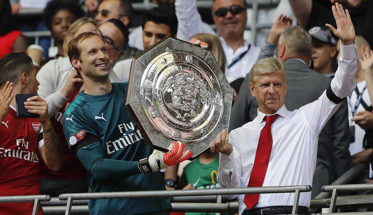 Arsene Wenger (kanan) akhirnya mengangkat trofi juara setelah timnya mengalahkan Chelsea lewat adu penalti 4-1 pada Community Shield 2017  di Wembley Stadium, London, (6/8/2017). (AFP/Frank Augstein)
