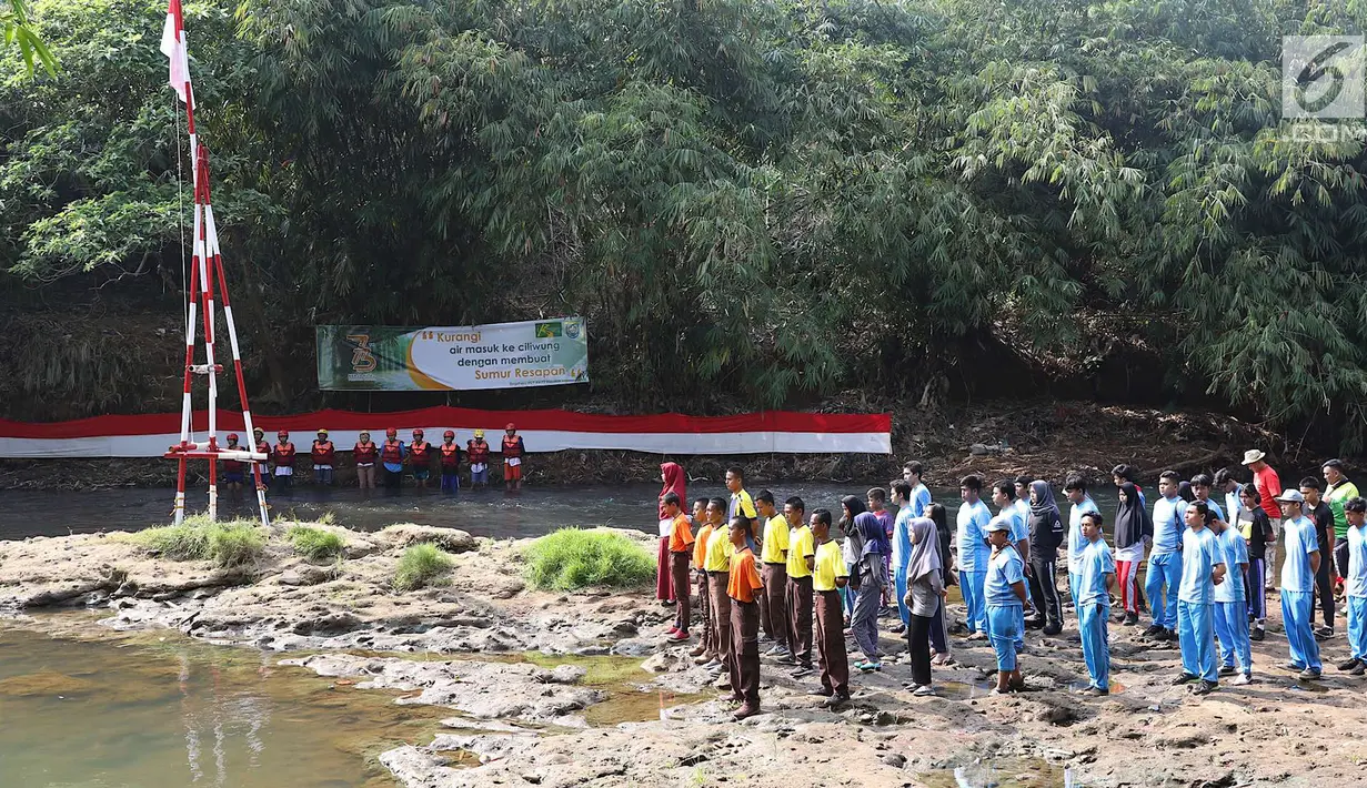 Komunitas Ciliwung bersama pelajar dan warga mengikuti upacara bendera di Sungai Ciliwung, Depok, Jumat (17/8). Upacara HUT ke-73 RI tersebut bertujuan mengedukasi masyarakat untuk menjaga kelestarian Sungai Ciliwung. (Liputan6.com/Immanuel Antonius)