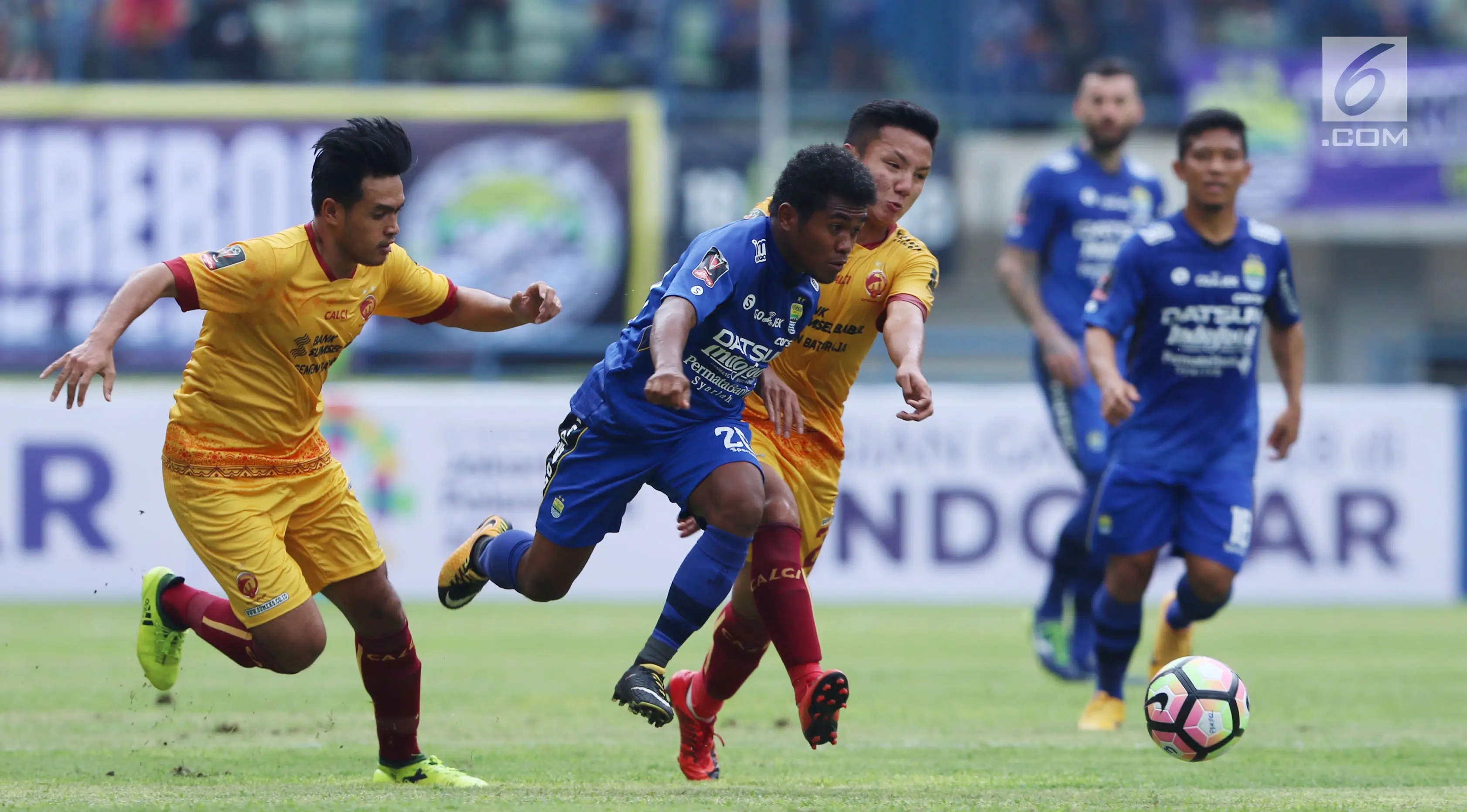 Gelandang Persib, Fulgensius Billy Paji Keraf (kedua kiri) mencoba lolos dari kawalan pemain Sriwijaya FC saat laga pembuka Piala Presiden 2018 di Stadion GBLA, Bandung, Selasa (16/1). (/Helmi Fithriansyah)